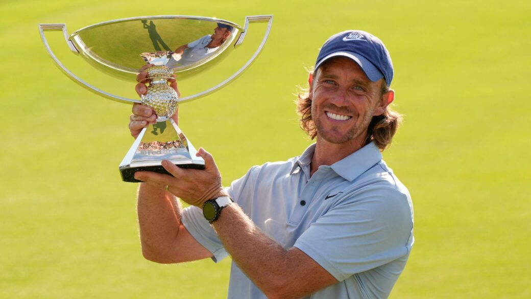 Tommy Fleetwood lifts the Tour Championship trophy after his first PGA Tour win.