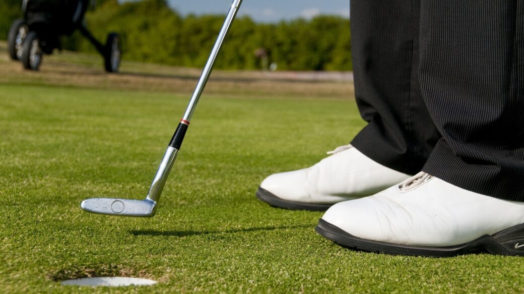 A close-up shot of a male golfer putting