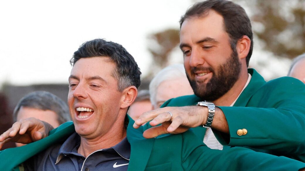 2024 Masters champion Scottie Scheffler holds the traditional green jacket for Rory McIlroy